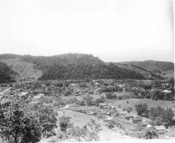 Black and white landscape image of hilly countryside. Several buildings, encompassing the town of Prestonsburg, Ky, are seen in the foreground.
